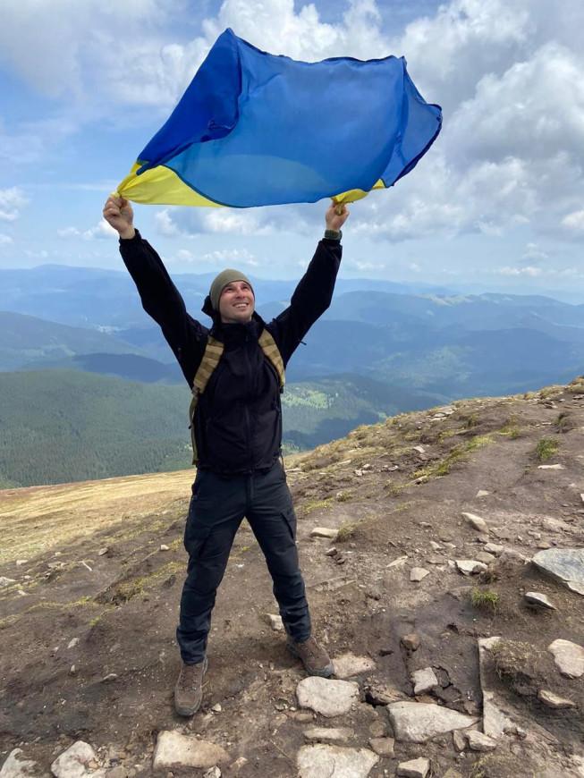 Андрій Приймаченко зі стягом України на вершині гори